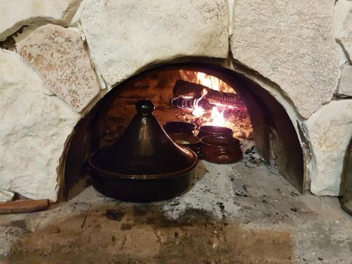 a brick oven with a pot and pans in it at Gle-Alb AgroTourism in Tepelenë