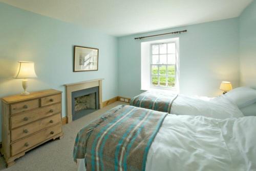 - une chambre avec 2 lits et une cheminée dans l'établissement Kirknowe, à Jedburgh
