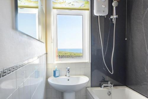 a bathroom with a sink and a window at Melvin Cottage in Embleton