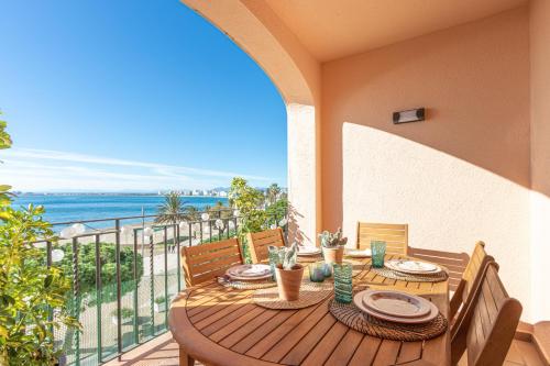 a table on a balcony with a view of the ocean at BADIA DE ROSES 1 new apartment in Roses