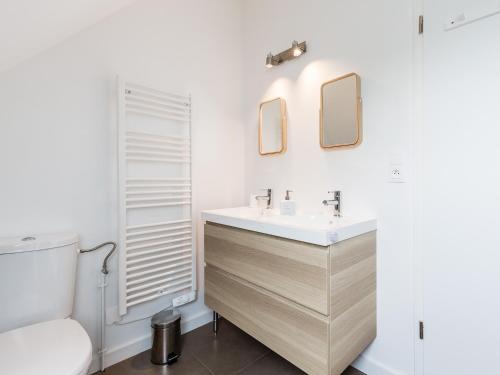 a bathroom with a sink and a toilet at La Grange in Birkenwald