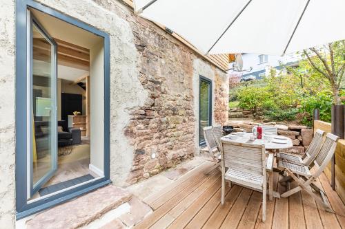 a patio with a table and chairs and an umbrella at La Grange in Birkenwald