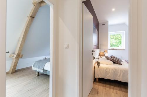 a white bedroom with a bed and a window at La Grange in Birkenwald