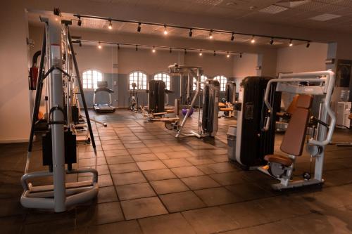 a gym with several treadmills and elliptical machines at Assiut Cement Hotel in Asyut