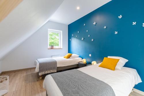 two beds in a room with a blue wall at La Grange in Sommerau