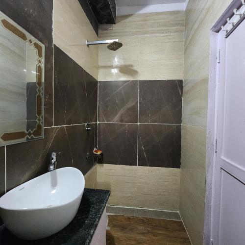 a bathroom with a white sink and a shower at HOTEL ROYAL AFGHAN in New Delhi
