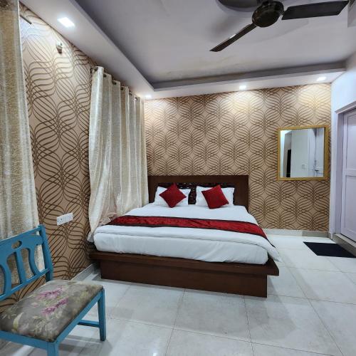 a bedroom with a bed and a blue chair at HOTEL ROYAL AFGHAN in New Delhi