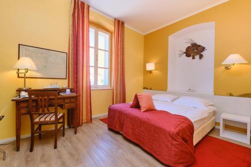 a hotel room with a bed and a desk at Mare Mare Suites in Mali Lošinj
