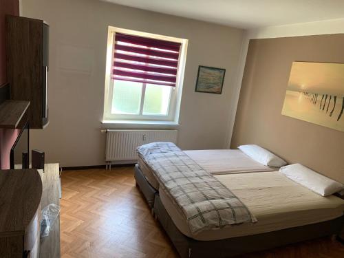 ein Schlafzimmer mit einem Bett und einem Fenster in der Unterkunft LEA Apartments Leipzig West in Leipzig