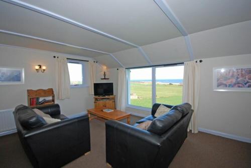 a living room with two couches and a table at Longstone in Embleton