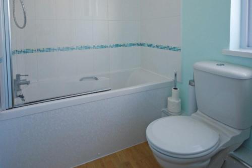 a bathroom with a toilet and a bath tub at Longstone in Embleton