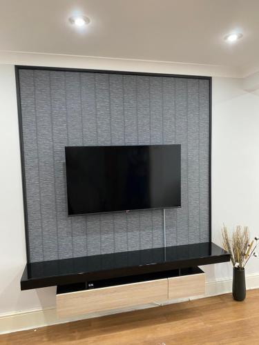 En TV eller et underholdningssystem på Large 4 Bedrooms House in Coventry for Contractors