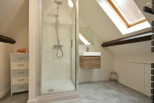 a bathroom with a shower in a attic at Old Stable Cottage in Alnmouth