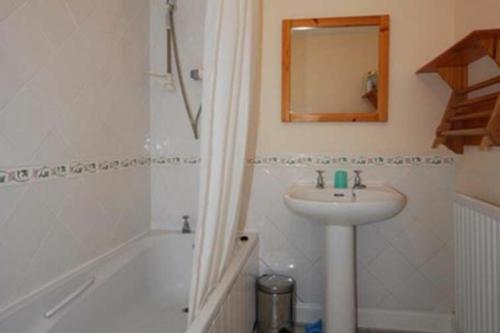 a bathroom with a sink and a shower and a mirror at Snook Point Cottage in Newton-by-the-Sea