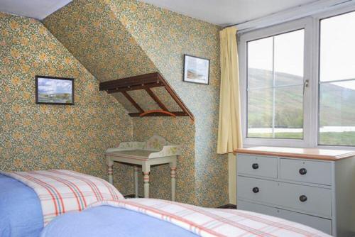 1 dormitorio con cama, lavabo y ventana en Roughley Cottage en Newcastleton