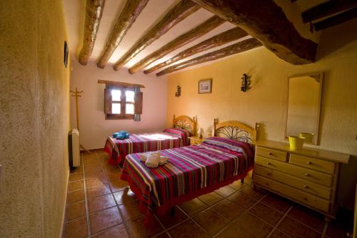a bedroom with two beds and a dresser in a room at Casa La Mestra in Herbeset