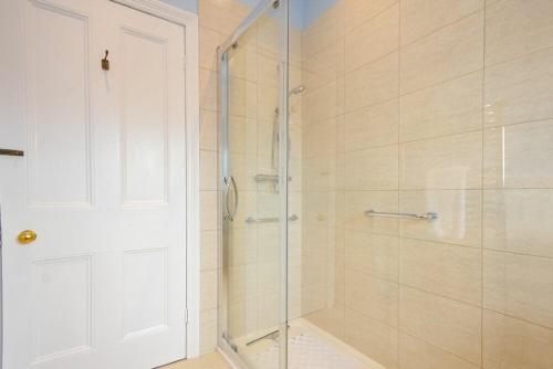 a bathroom with a shower with a glass door at Ty y Mor in Seahouses