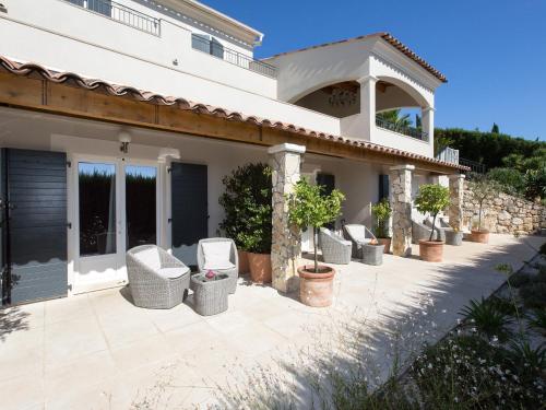 un patio con sedie in vimini di fronte a una casa di Les chambres d'hôtes de Mougins a Mougins