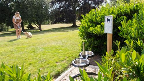 a woman walking a dog in a park with a grill at Eastwood Hall in Eastwood