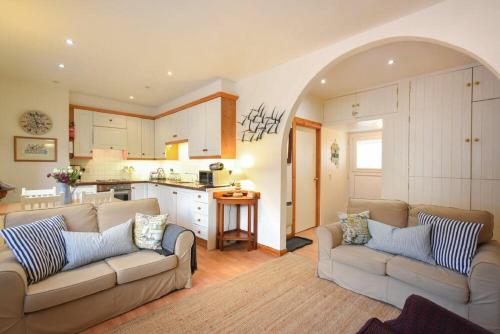 a living room with two couches and a kitchen at Spinnaker in Embleton