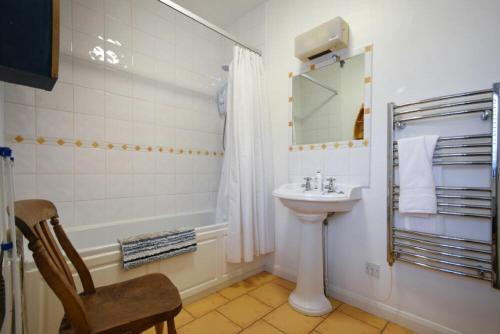 bagno con lavandino, vasca e specchio di Spinnaker a Embleton