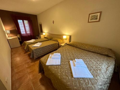a hotel room with two beds with towels on them at Domus San Bernardino in Verona