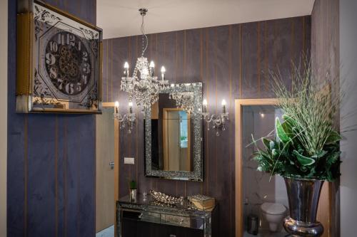 a bathroom with a chandelier and a mirror at TATRYSTAY Private Apartments Hrebienok in Starý Smokovec