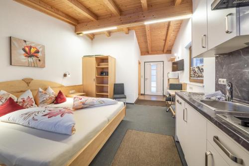 a bedroom with a large bed and a kitchen at Appartementhaus im Winkel in Sölden