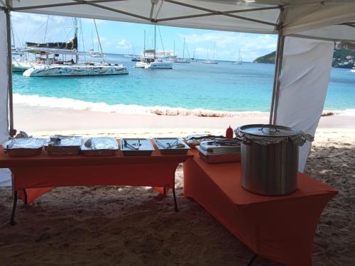 a picnic table on the beach with boats in the water at Spring Hotel Bequia in Port Elizabeth