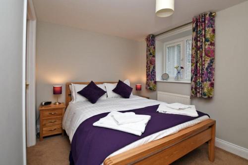 1 dormitorio con 1 cama con 2 toallas en Schooner Court No2, en Alnmouth