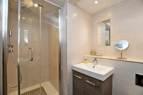 a bathroom with a shower and a sink and a mirror at Schooner Court No2 in Alnmouth