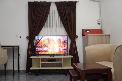 a living room with a television and a couch at Ebrina Apartments in Port Harcourt