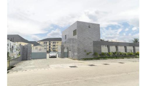 een stenen gebouw met een auto geparkeerd op een parkeerplaats bij Ebrina Apartments in Port Harcourt