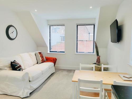 a living room with a white couch and a table at Huntingdon Lodge in Huntingdon