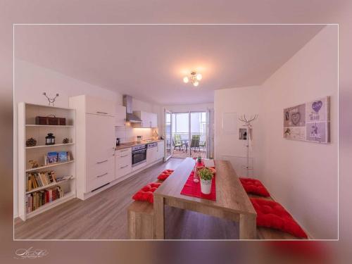 a large white kitchen with a wooden table in a room at Fewo Müritzfrische 1 in Waren