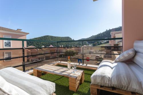 a balcony with two beds and a table on the grass at Luxe villa Sesimbra secret corner 2 in Sesimbra