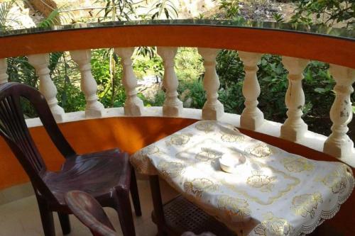 a chair sitting on a balcony with a table and a bowl at Mayelle Agonda in Agonda