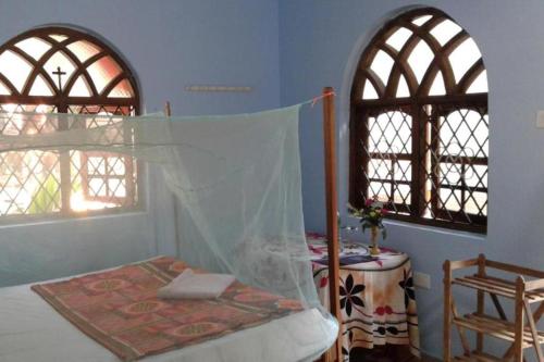 阿貢達的住宿－Mayelle Agonda，一间卧室设有一张床和两个窗户。