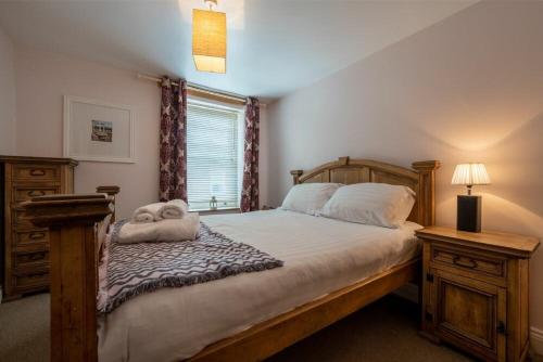 a bedroom with a large bed with a wooden headboard at Pilots Rest in Alnmouth