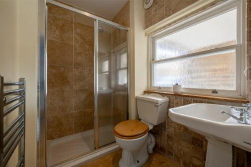 a bathroom with a toilet and a sink and a shower at Pilots Rest in Alnmouth