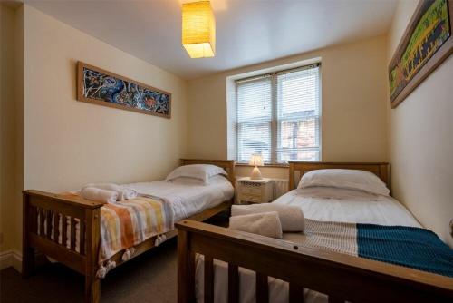 a bedroom with two beds and a window at Pilots Rest in Alnmouth