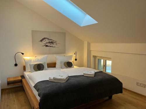 ein Schlafzimmer mit einem großen Bett mit zwei Handtüchern darauf in der Unterkunft Gmunder Premium Dachgeschoss-Apartments in Gmund am Tegernsee
