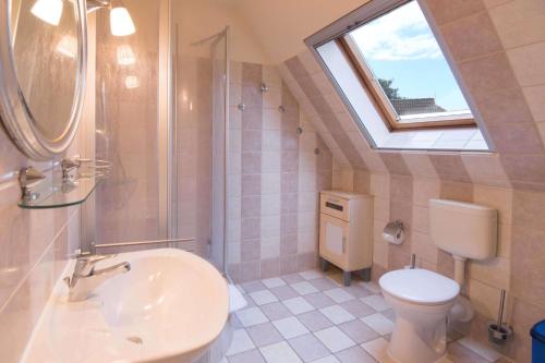 a bathroom with a sink and a toilet and a window at Ferienhaussiedlung Strandperlen Sanddornhof 3a (Typ VIII) in Wustrow