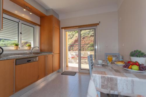 a kitchen with a table with a bowl of fruit on it at Luxe villa Sesimbra secret corner 2 in Sesimbra