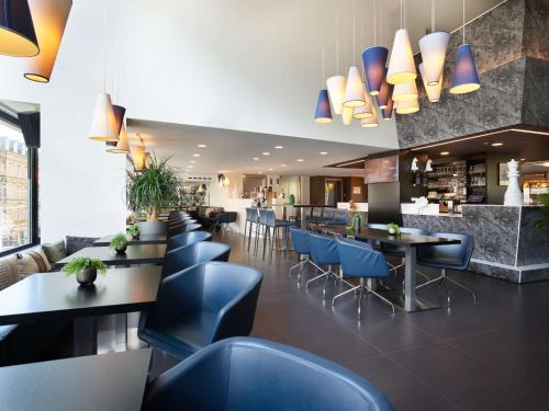 um restaurante com mesas e cadeiras azuis em Park Inn by Radisson Luxembourg City no Luxemburgo
