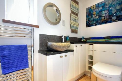 ein Bad mit einem Waschbecken und einem Spiegel in der Unterkunft Rock End in Seahouses