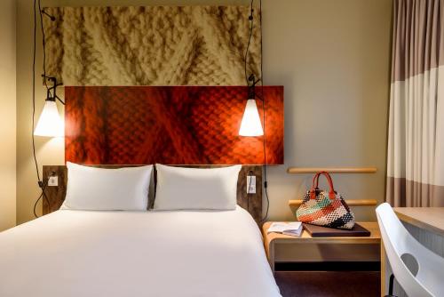 a hotel room with a bed and two lamps at Ibis Irun in Ir&uacute;n