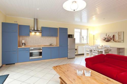 ein Wohnzimmer mit blauen Schränken und einer roten Couch in der Unterkunft FH Wendorff in Klink