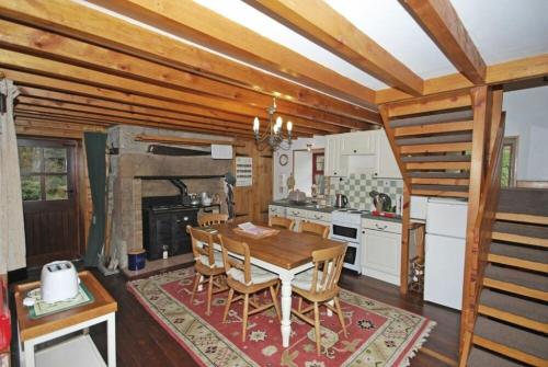 a kitchen with a wooden table and a dining room at The Old School House in Alwinton