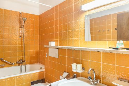 y baño con lavabo, bañera y espejo. en Haus Excelsior Top 5, en Seefeld in Tirol